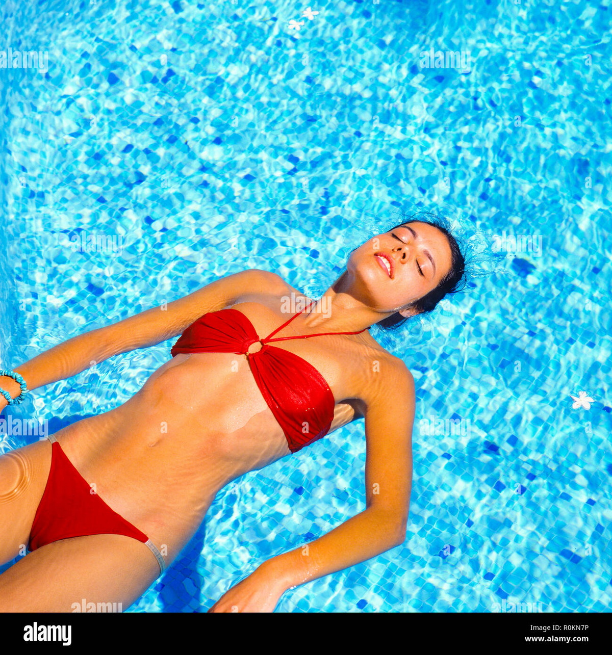 young woman with red bikini floating on water in swimming pool guadeloupe french west indies グアドループ フランス領西インド諸島のスイミング プールの水に浮かぶ赤いビキニの若い女性